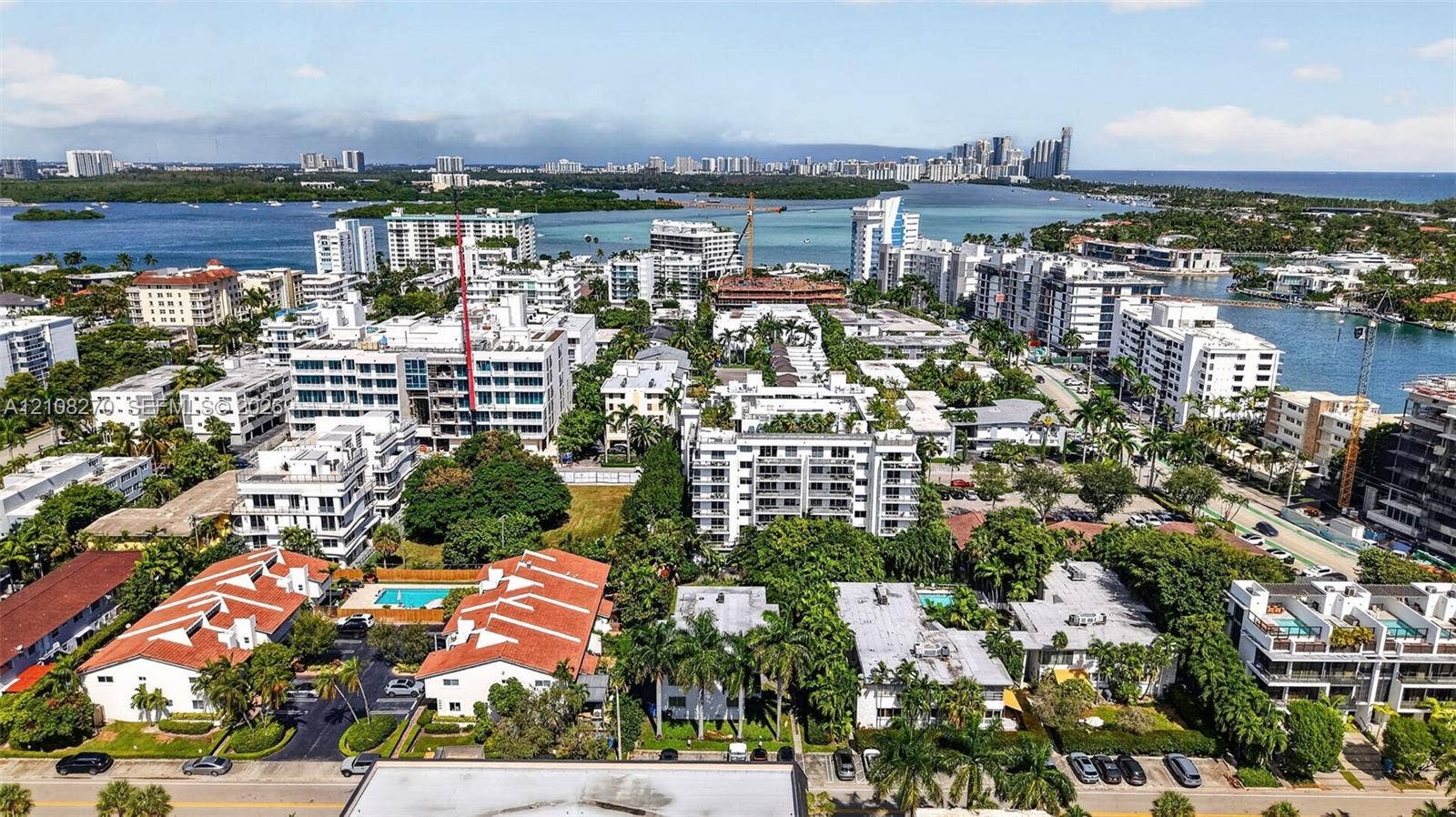 1125 99th Street, #12, Bay Harbor Islands, FL 33154 Aerial perspective of a coastal residential area featuring multi-level structures, terracotta-style roof tiles, established tropical landscaping, and proximity to expansive waterways