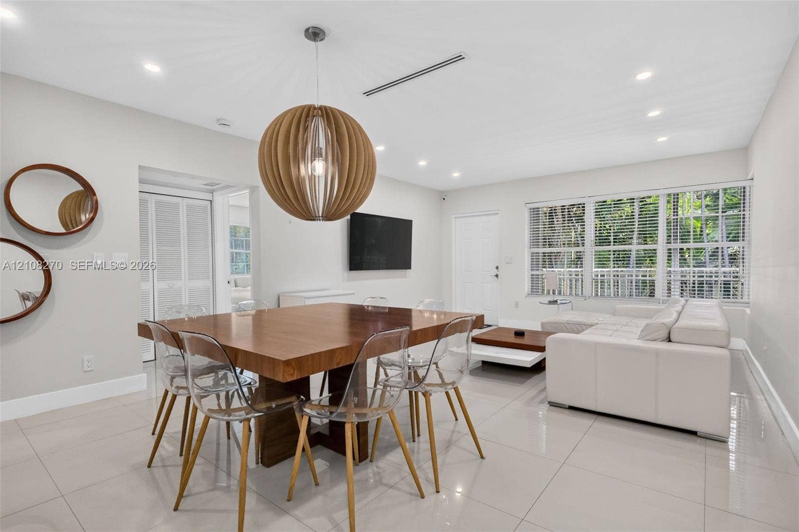 1125 99th Street, #12, Bay Harbor Islands, FL 33154 Open-concept area featuring polished tile flooring, recessed ceiling lighting, a spherical wooden pendant fixture, and large multi-pane windows