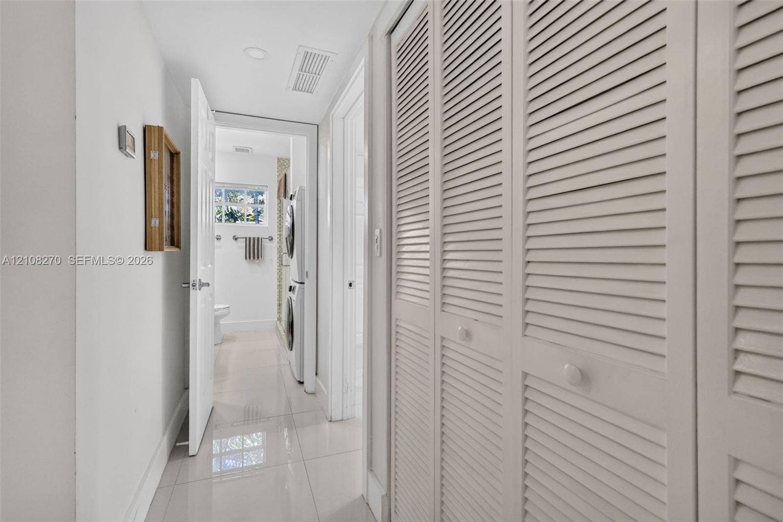 1125 99th Street, #12, Bay Harbor Islands, FL 33154 Hallway featuring full-height louvered closet doors, polished tile flooring, and recessed ceiling lighting