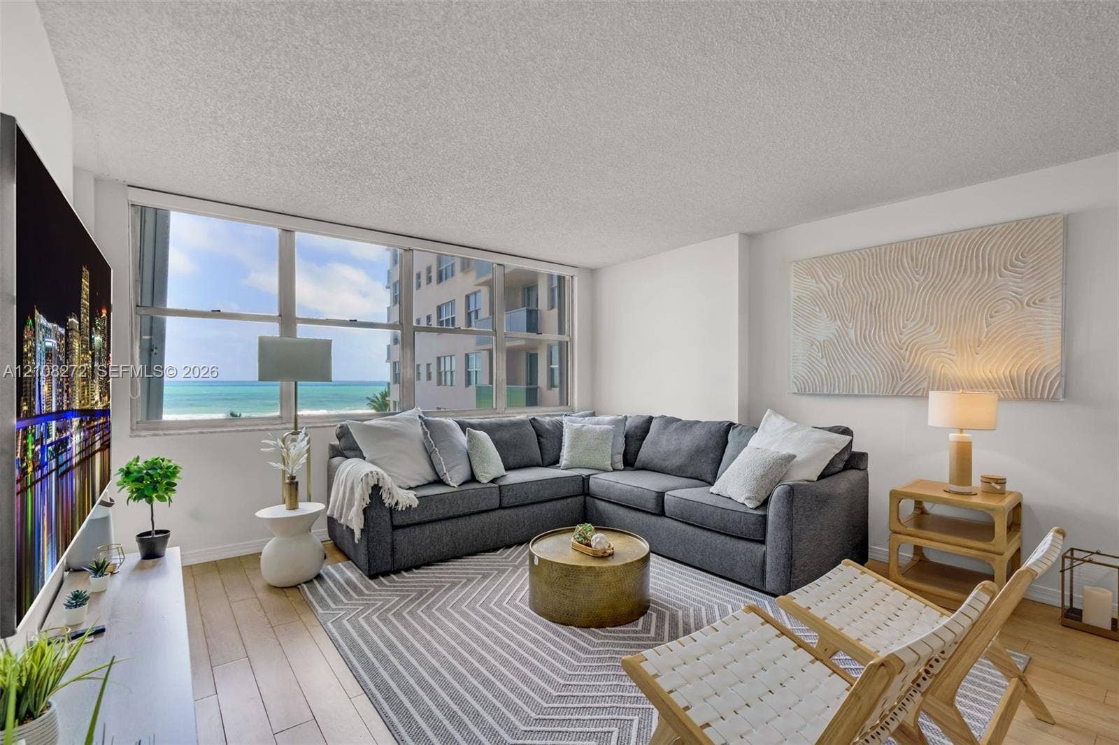Living area featuring floor-to-ceiling windows, wood-finish flooring, and ocean exposure