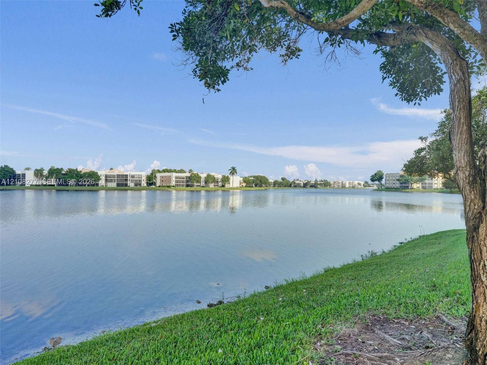 7466 Ashmont Circle, #303, Tamarac, FL 33321 Waterfront scenery featuring a expansive lake, manicured grass shoreline, and mature trees