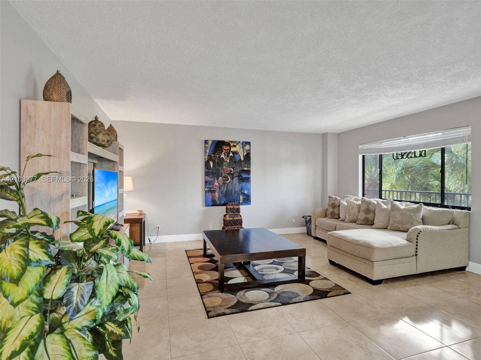 7466 Ashmont Circle, #303, Tamarac, FL 33321 Neutral-toned tile flooring, built-in floor-to-ceiling shelving, and expansive window with integrated blind