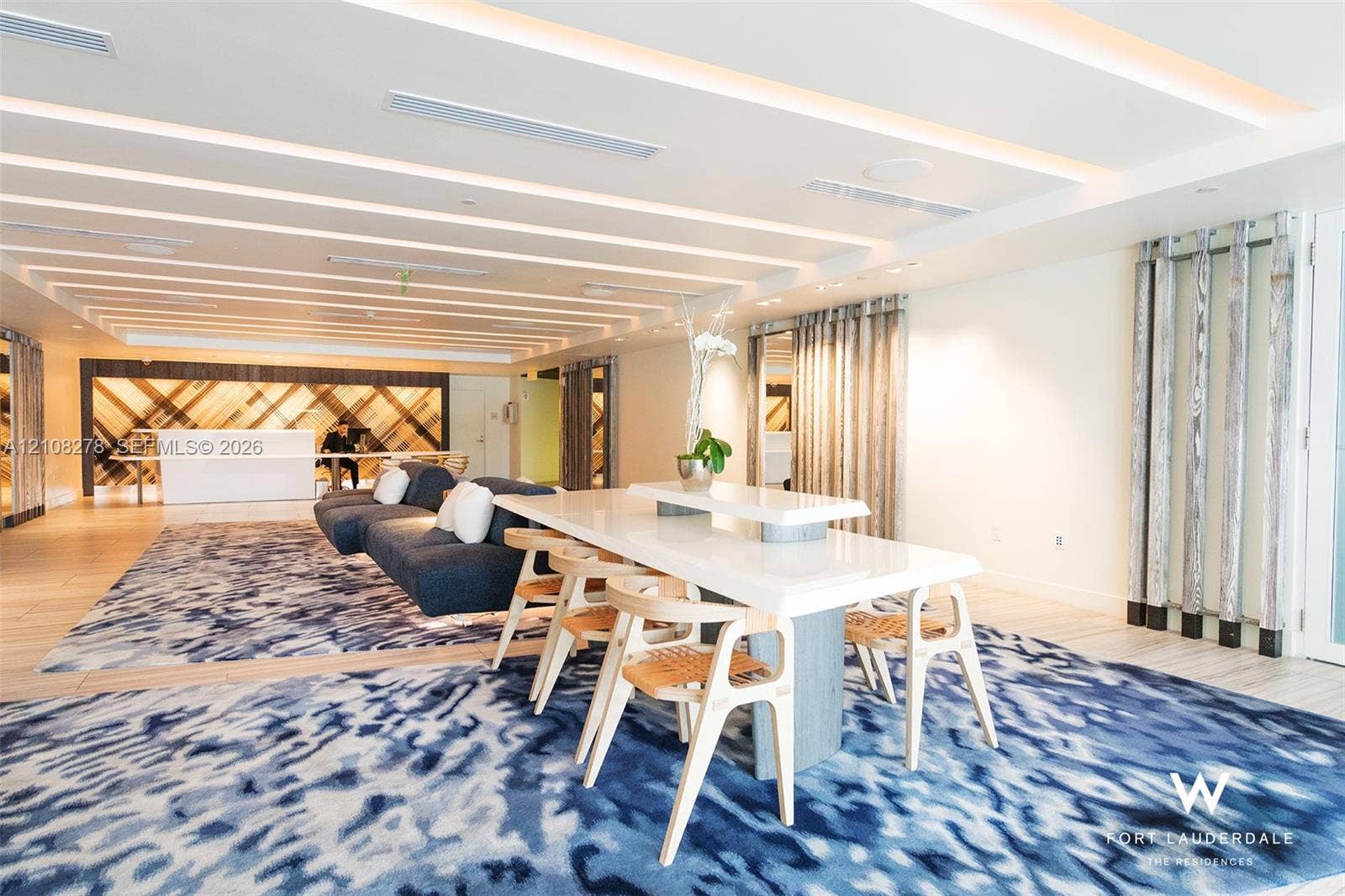 3101 Bayshore Drive, #701, Fort Lauderdale, FL 33304 Tray ceiling with integrated linear lighting, chevron-patterned wood accent wall, and wood-finish flooring
