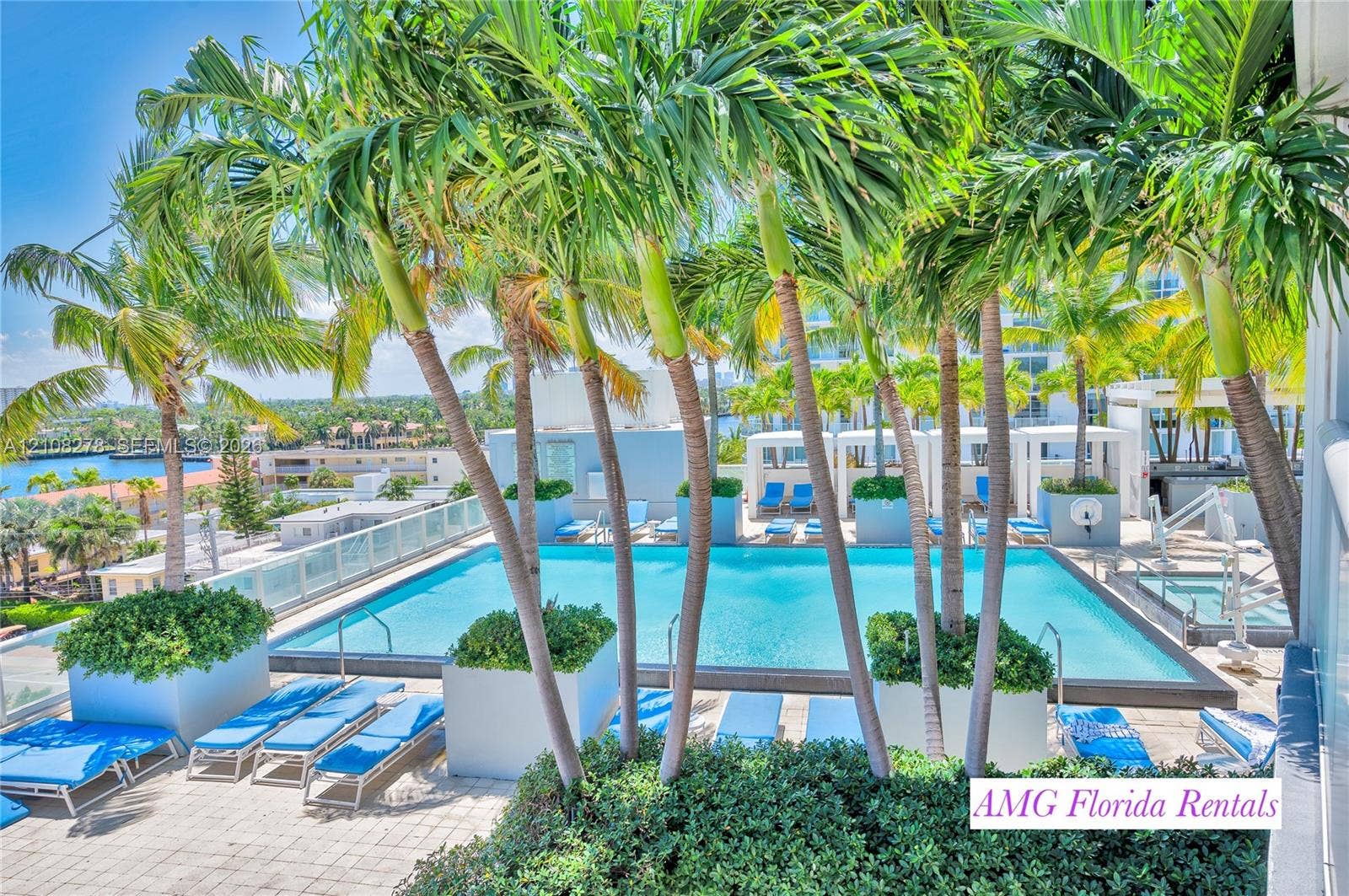3101 Bayshore Drive, #701, Fort Lauderdale, FL 33304 Swimming pool terrace featuring a stone-paved deck, integrated tropical landscaping, and a glass-paneled perimeter railing