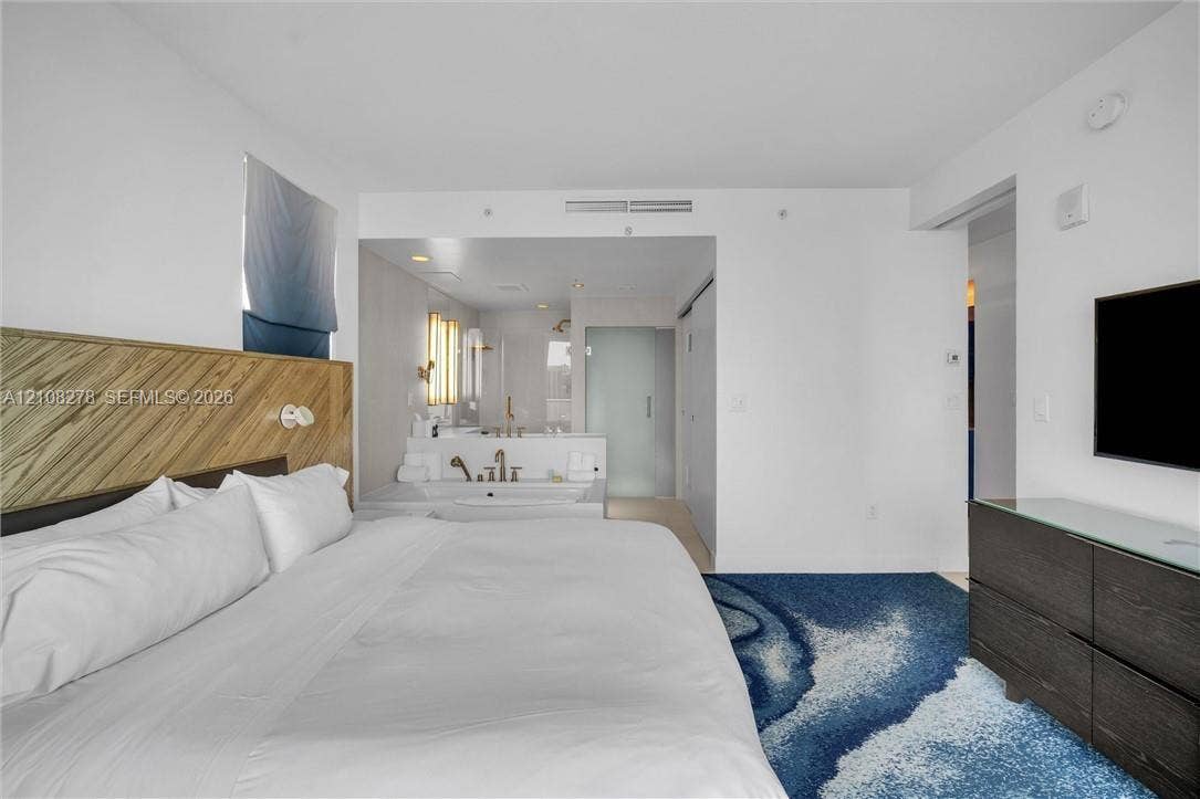3101 Bayshore Drive, #701, Fort Lauderdale, FL 33304 Custom wood-slat headboard feature wall, integrated soaking tub, recessed lighting, and wall-mounted plumbing fixtures