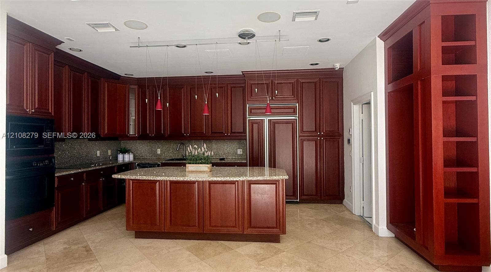 19424 39th Avenue, Sunny Isles Beach, Sunny Isles Beach, FL 33160 Kitchen featuring deep-toned custom cabinetry, central island with stone countertop, built-in panel-ready refrigerator, integrated wall oven, and stone tile flooring