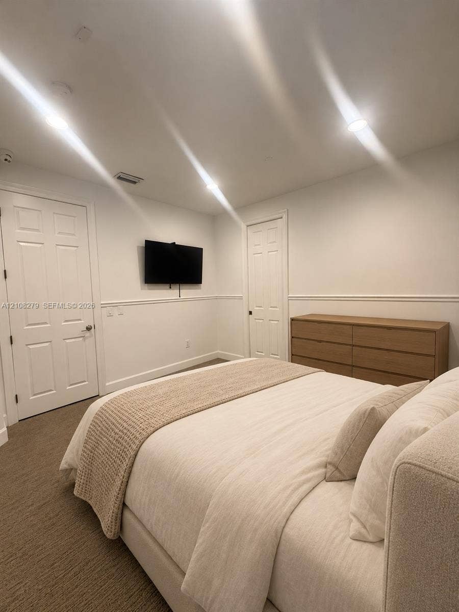 19424 39th Avenue, Sunny Isles Beach, Sunny Isles Beach, FL 33160 Neutral-toned carpeted flooring, wall-mounted television, recessed lighting, chair rail molding, and two-panel interior doors