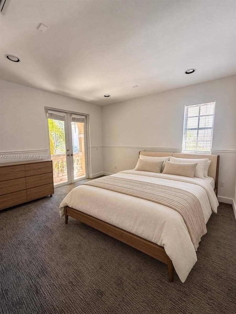 19424 39th Avenue, Sunny Isles Beach, Sunny Isles Beach, FL 33160 Bedroom interior featuring neutral wall-to-wall carpeting, recessed ceiling lighting, chair rail molding, a double-hung window, and glass-paneled french doors