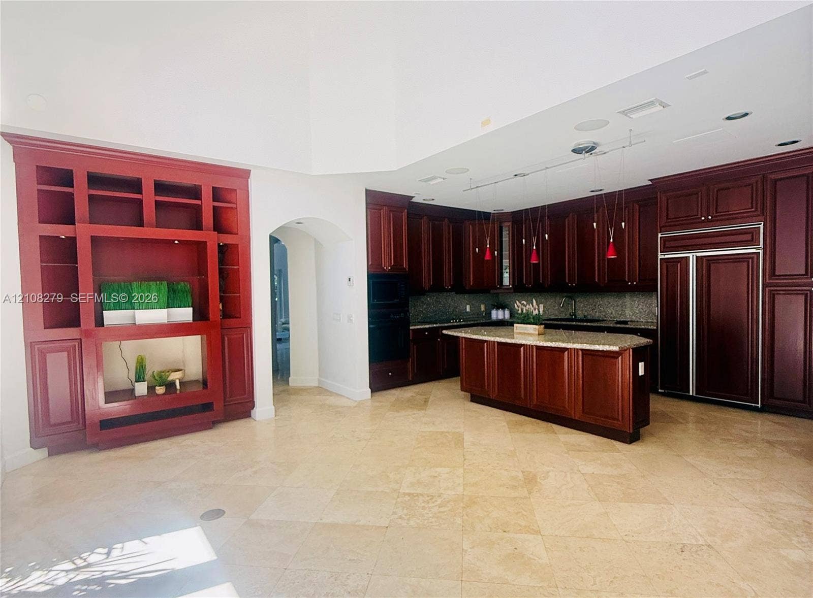 19424 39th Avenue, Sunny Isles Beach, Sunny Isles Beach, FL 33160 Kitchen featuring custom stained-wood cabinetry, stone countertops, central island, built-in panel-ready refrigerator, and stone tile flooring
