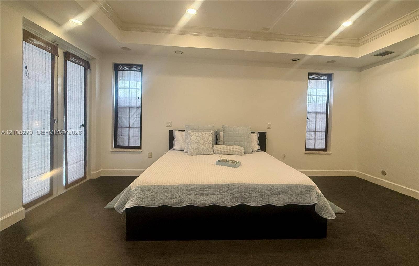 19424 39th Avenue, Sunny Isles Beach, Sunny Isles Beach, FL 33160 Tray ceiling featuring recessed lighting, dark carpeting, and dual-panel glass doors