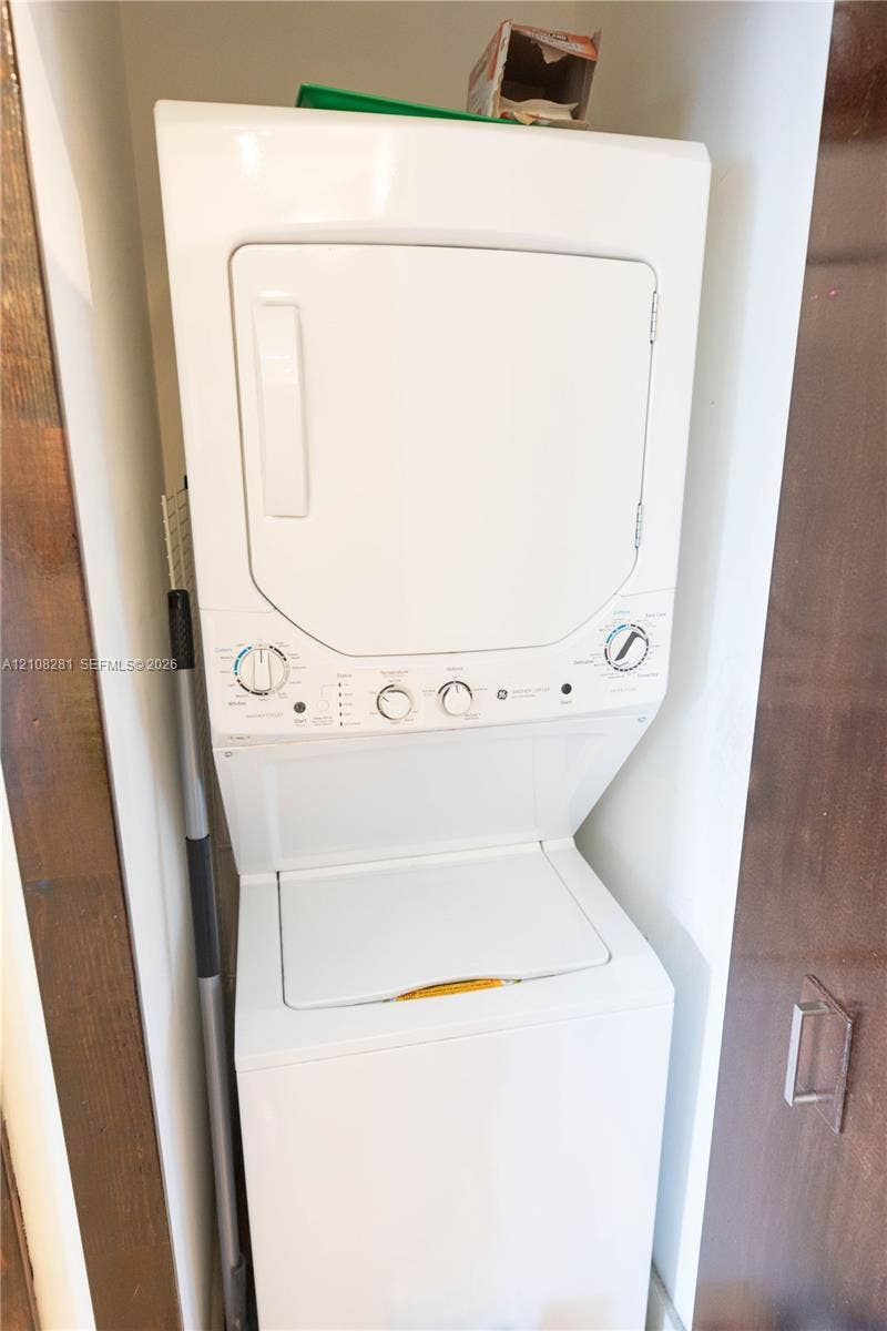 White stacked laundry center with top-load washer and front-load dryer configuration