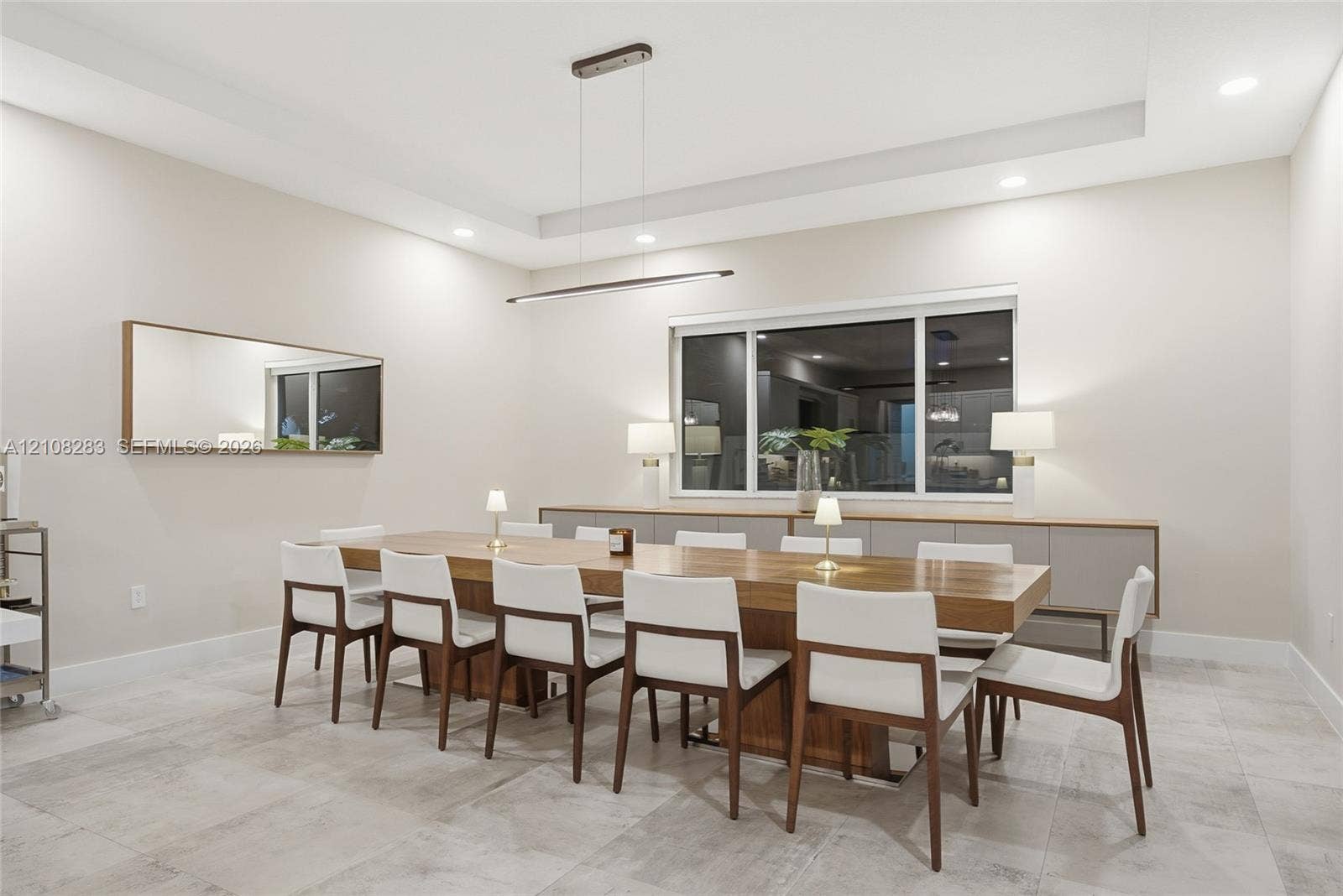 15215 SW 176th Lane, Miami, FL 33187 Tray ceiling with recessed lighting, linear pendant fixture, large-format tile flooring, and built-in cabinetry featuring a smooth countertop