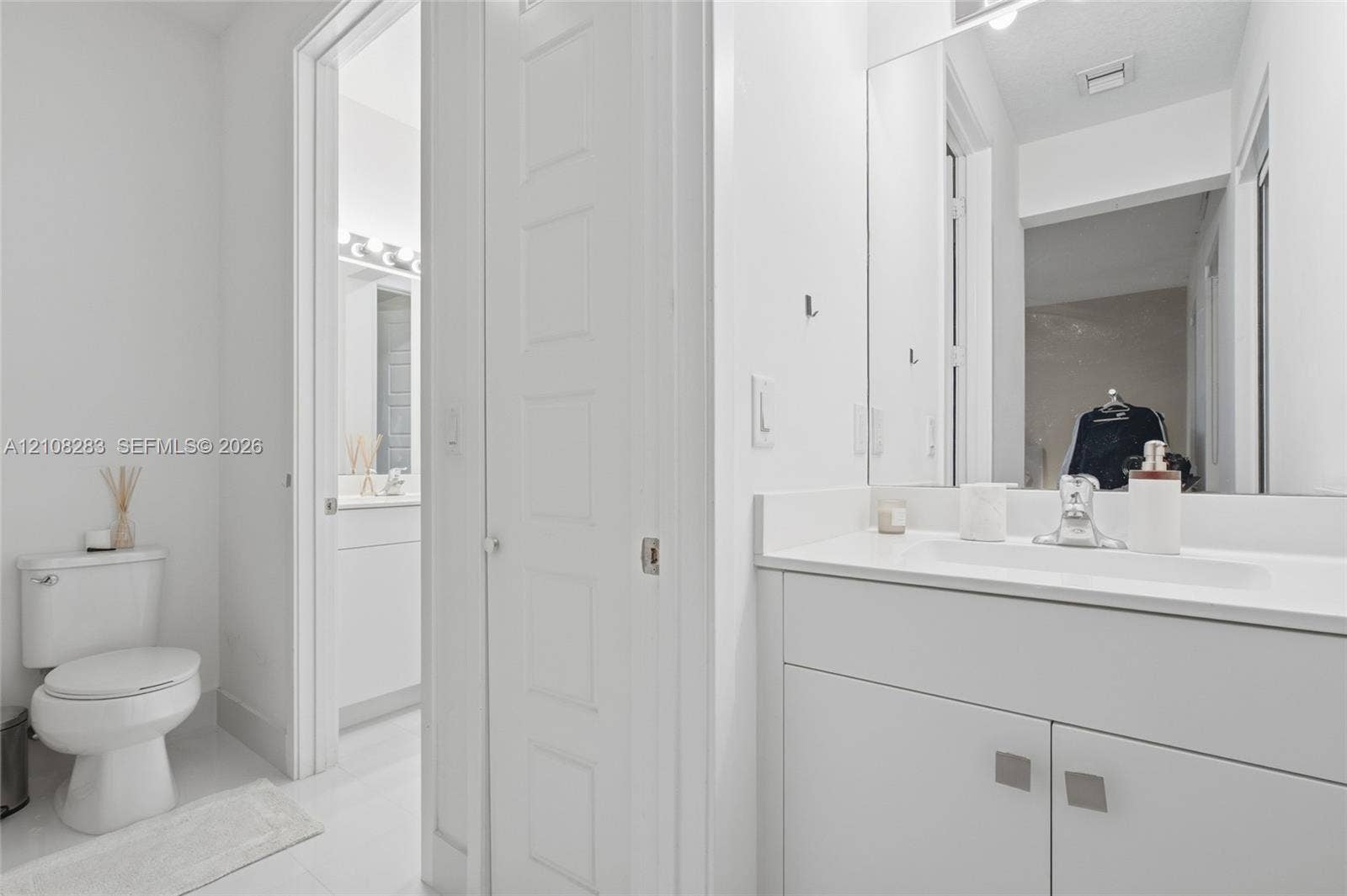 15215 SW 176th Lane, Miami, FL 33187 Bathroom featuring a white vanity cabinet with a stone-top integrated sink, a full-height wall mirror, a polished chrome faucet, and a standard-height toilet