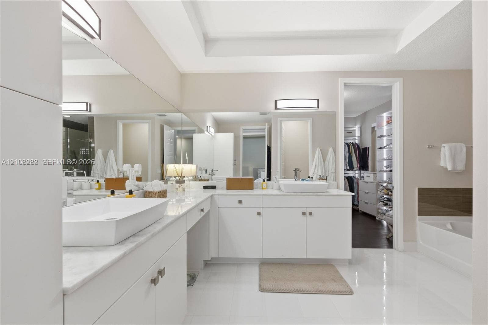 15215 SW 176th Lane, Miami, FL 33187 Dual vanity featuring rectangular vessel sinks, white stone countertops, white cabinetry with brushed metallic hardware, and full-width wall mirrors