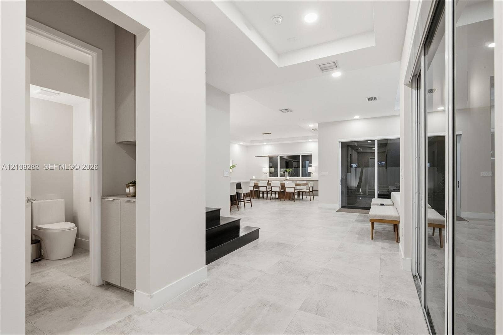 15215 SW 176th Lane, Miami, FL 33187 Interior space featuring large-format tile flooring, recessed ceiling lighting, tray ceilings, built-in cabinetry, and sliding glass doors