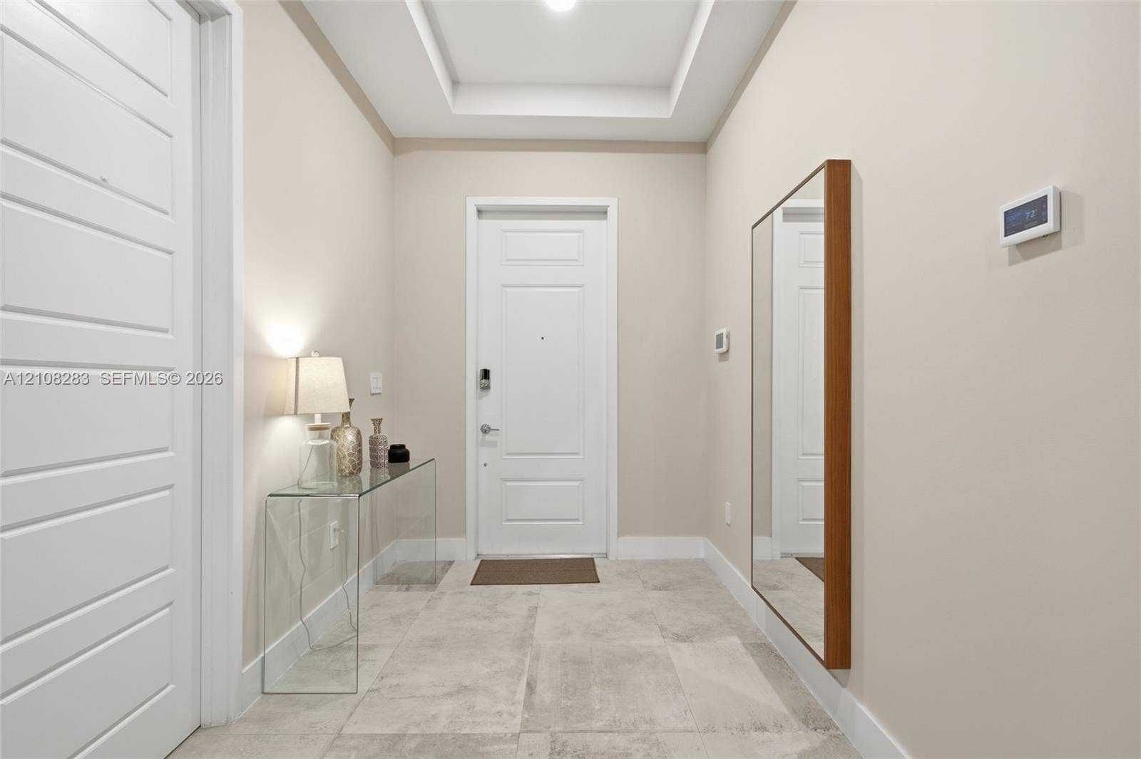 15215 SW 176th Lane, Miami, FL 33187 Entryway featuring large-format tile flooring, a tray ceiling, and a paneled entry door