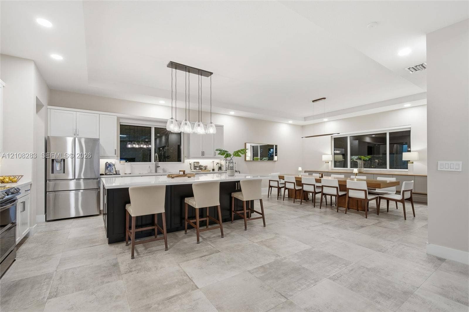 15215 SW 176th Lane, Miami, FL 33187 Kitchen featuring a center island with contrasting cabinetry, stone-finish countertops, stainless steel appliances, recessed ceiling lighting, and large-format tile flooring