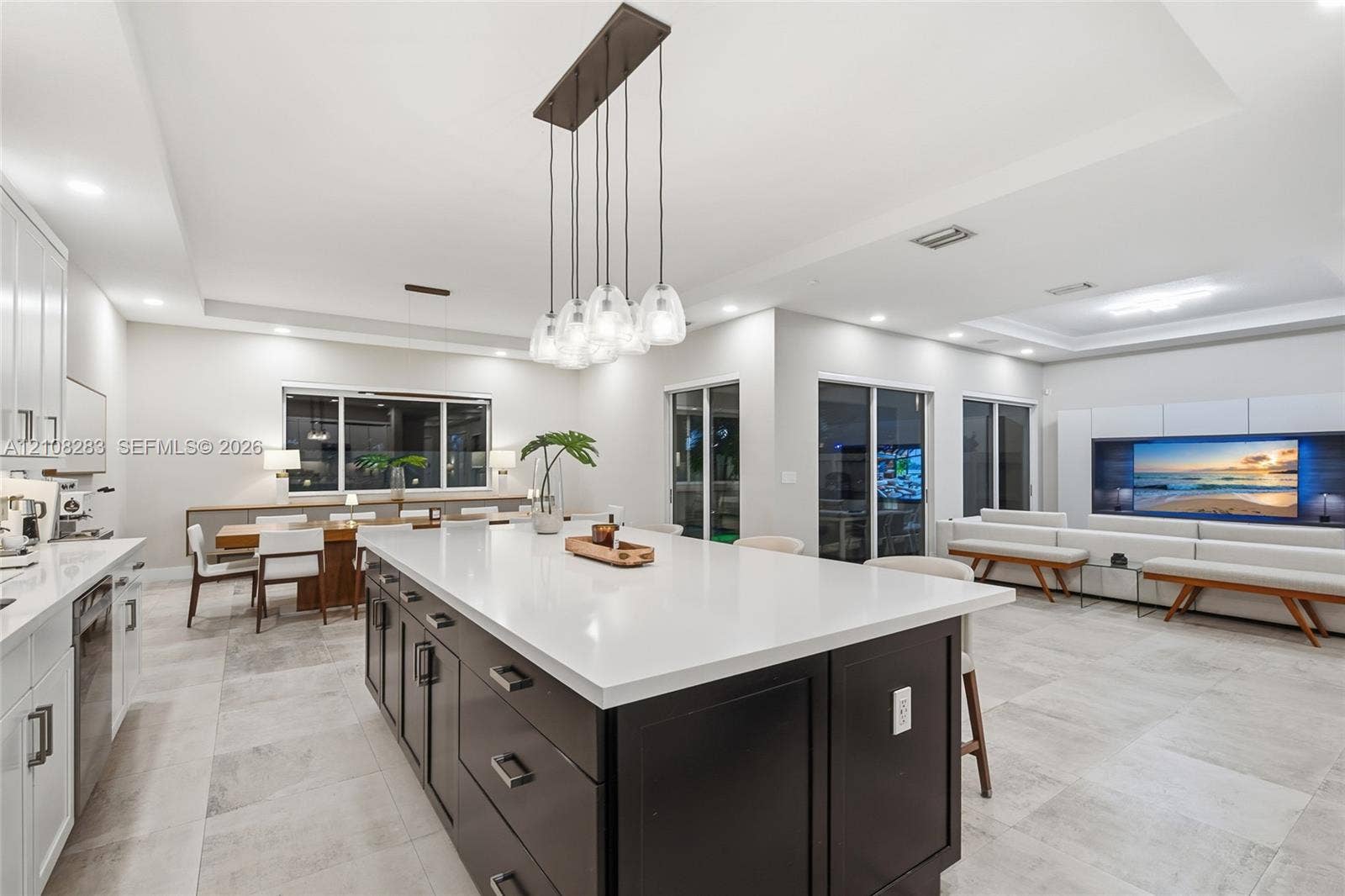 15215 SW 176th Lane, Miami, FL 33187 Kitchen featuring a center island with contrasting cabinetry, stone-finish countertops, tile flooring, built-in media console, and multi-pendant lighting