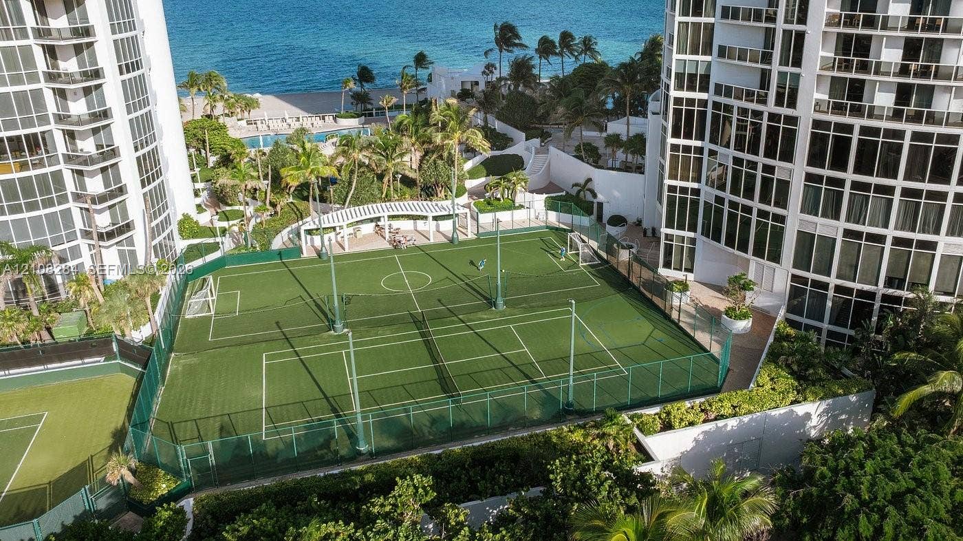18001 Collins Avenue, #908, Sunny Isles Beach, FL 33160 Multi-purpose athletic court featuring synthetic turf, perimeter fencing, and an integrated pergola