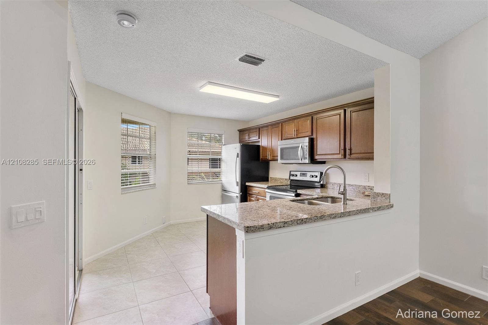 6626 Via Regina, #0, Boca Raton, Boca Raton, FL 33433 Kitchen featuring stone-finish countertops, stainless steel appliances, wood-finish cabinetry, and ceramic tile flooring