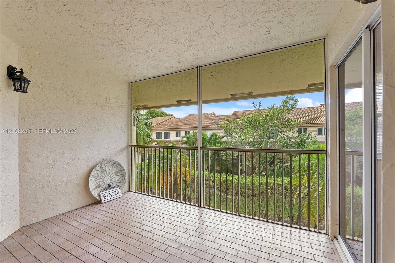 6626 Via Regina, #0, Boca Raton, Boca Raton, FL 33433 Covered balcony featuring tile flooring, metal railings, a screened enclosure, and wall-mounted exterior lighting