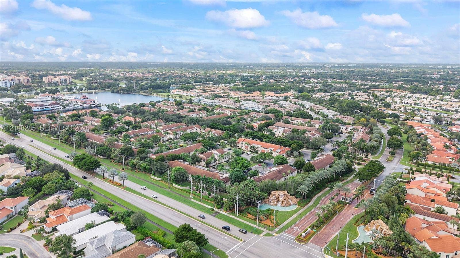 6626 Via Regina, #0, Boca Raton, Boca Raton, FL 33433 Aerial perspective of a multi-residential community featuring tile roofing, mature landscaping, paved roadways, and decorative rock water features