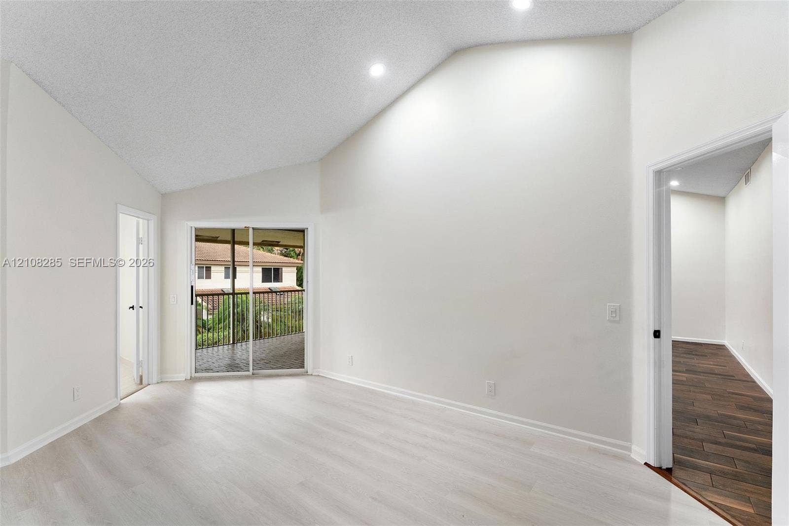 6626 Via Regina, #0, Boca Raton, Boca Raton, FL 33433 Vaulted ceilings featuring recessed lighting, light-toned wood-finish flooring, and sliding glass doors to a covered balcony