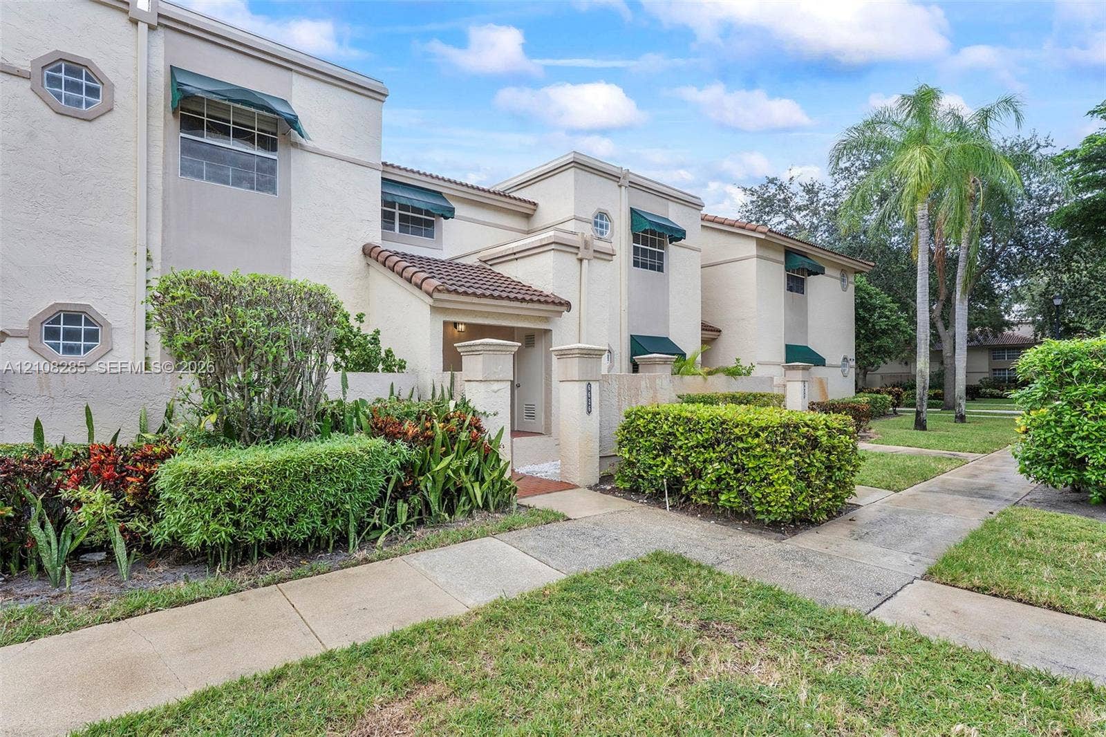 6626 Via Regina, #0, Boca Raton, Boca Raton, FL 33433 Multi-story stucco exterior featuring tile roofing, green window awnings, octagonal accent windows, and a paved walkway entry