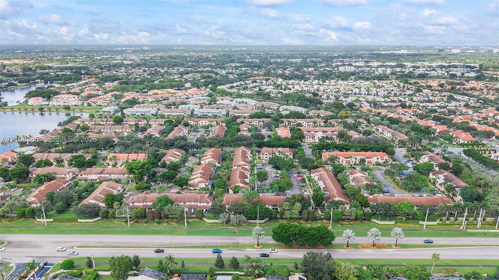 6626 Via Regina, #0, Boca Raton, Boca Raton, FL 33433 Aerial perspective of a multi-unit residential community featuring terracotta-style roofing, abundant mature landscaping, paved roadways, and proximity to a large body of water
