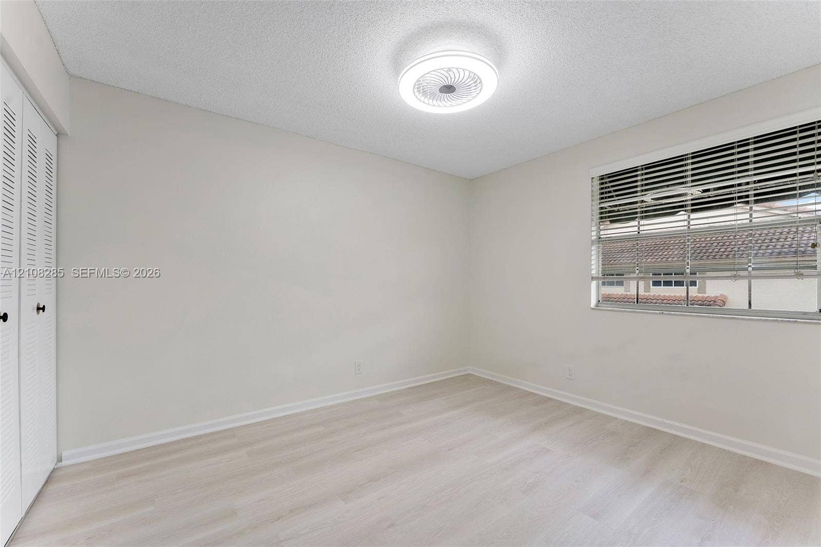 6626 Via Regina, #0, Boca Raton, Boca Raton, FL 33433 Light-toned wood-finish flooring, ceiling-mounted LED light fixture, double-door closet with louvered panels, and horizontal window blinds