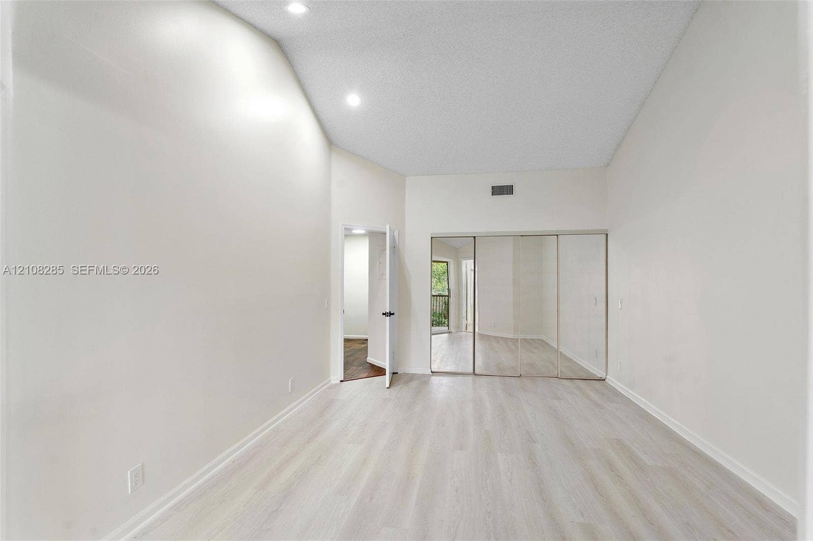 6626 Via Regina, #0, Boca Raton, Boca Raton, FL 33433 Vaulted ceilings featuring recessed lighting, light-toned wood-finish flooring, and mirrored closet doors