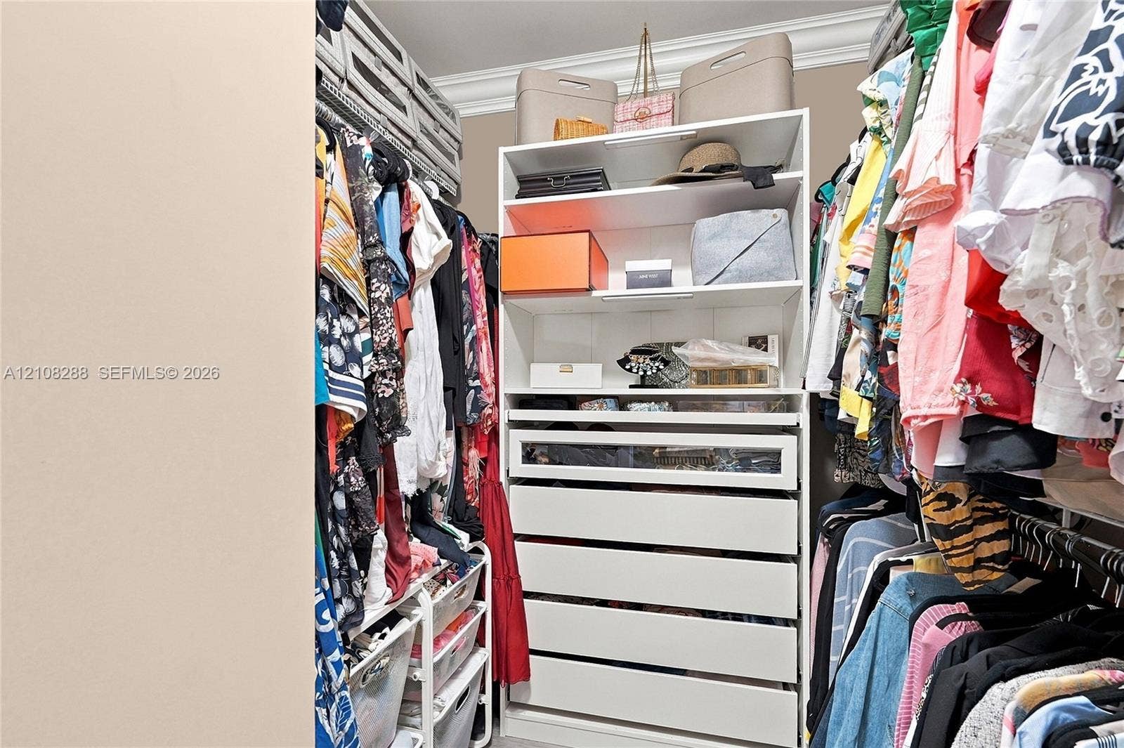 8292 NW 36th Street, Sunrise, FL 33351 Walk-in closet featuring white built-in cabinetry, floor-to-ceiling storage, a glass-front display drawer, and crown molding