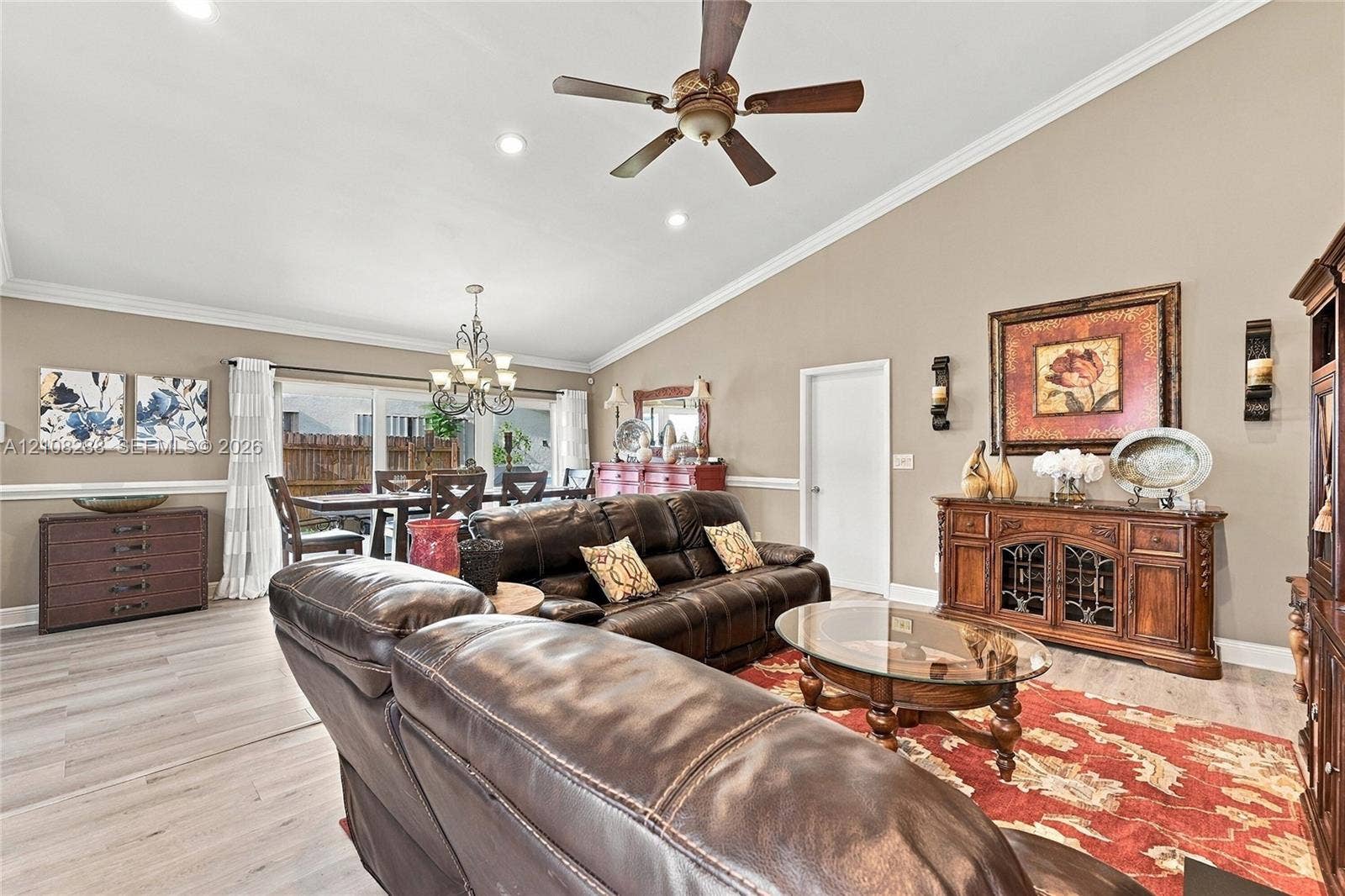 8292 NW 36th Street, Sunrise, FL 33351 Living area featuring a vaulted ceiling, wood-finish flooring, crown molding, chair rail trim, and a ceiling fan