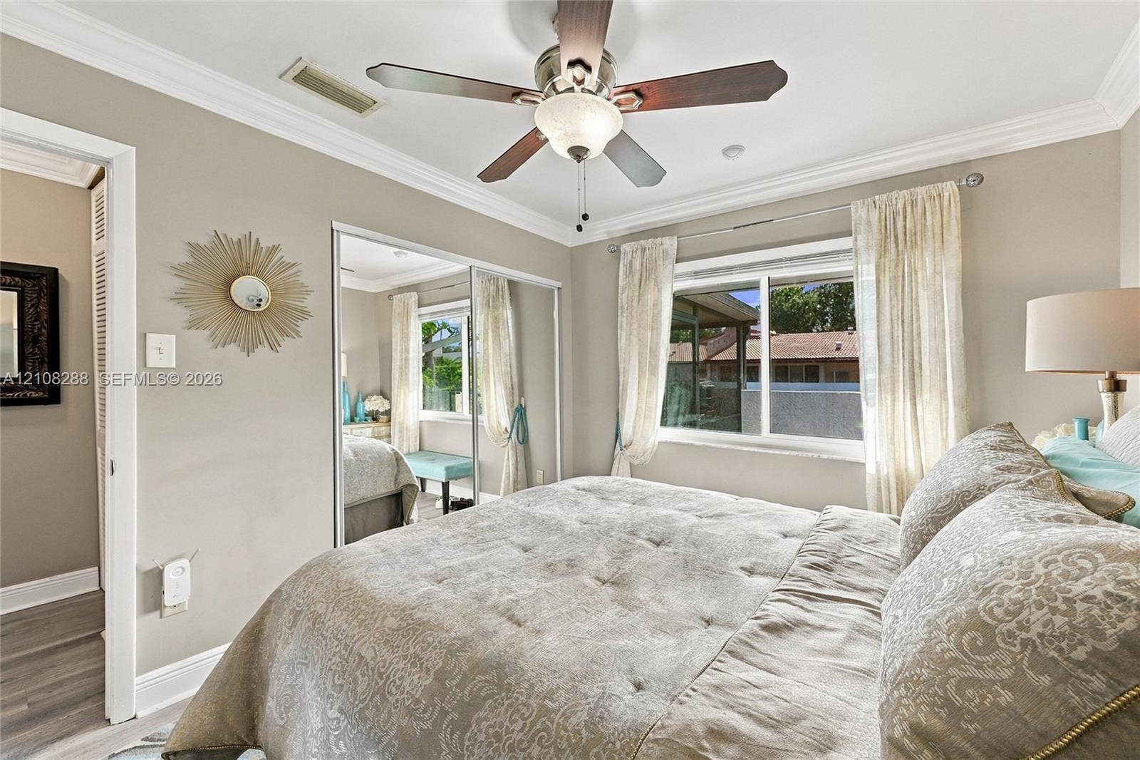 8292 NW 36th Street, Sunrise, FL 33351 Neutral-toned interior featuring crown molding, a ceiling fan with integrated lighting, and mirrored sliding closet doors
