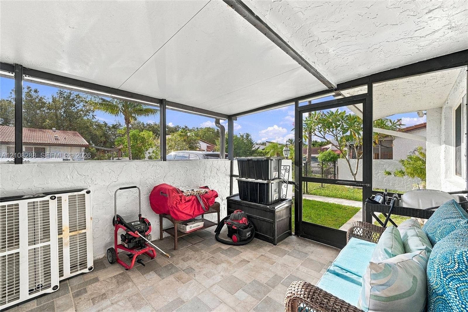 8292 NW 36th Street, Sunrise, FL 33351 Screened-in patio with tile flooring, textured stucco walls, and a metal-framed roof structure