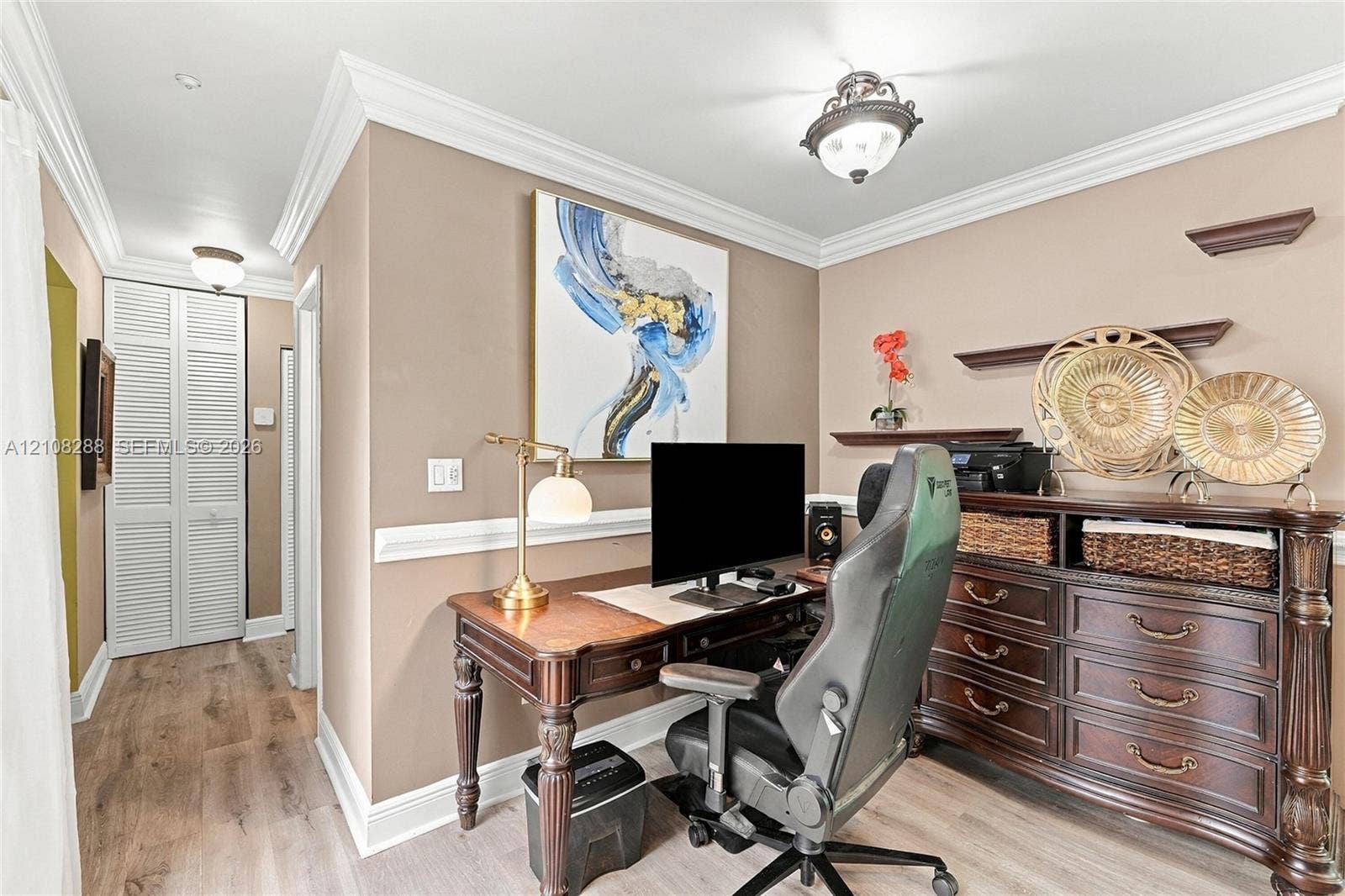 8292 NW 36th Street, Sunrise, FL 33351 Room featuring wood-finish flooring, crown molding, chair rail trim, louvered bi-fold closet doors, and a semi-flush mount ceiling fixture