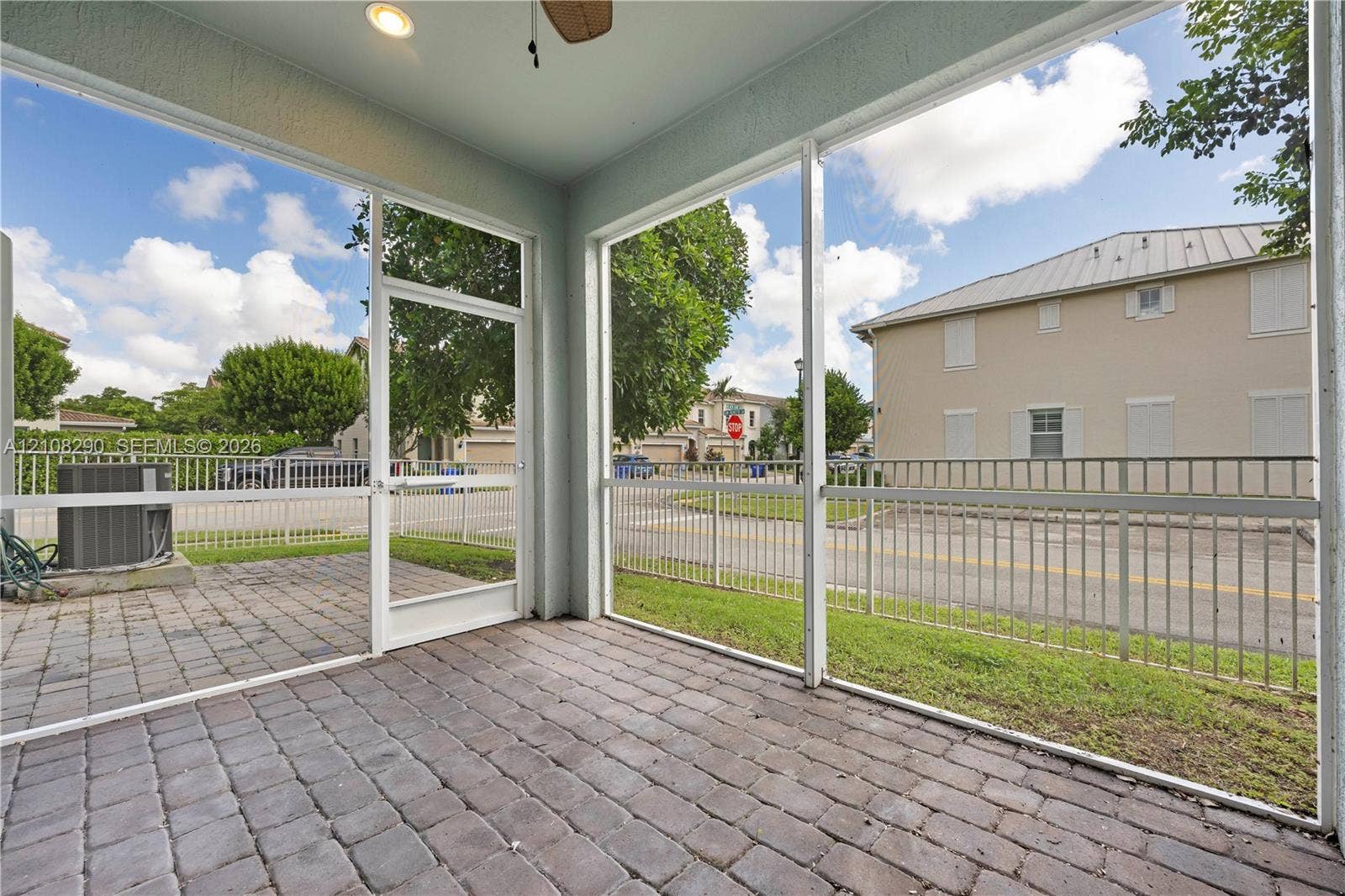 Screened-in patio featuring paver flooring, recessed ceiling lighting, a ceiling fan, and metal fencing