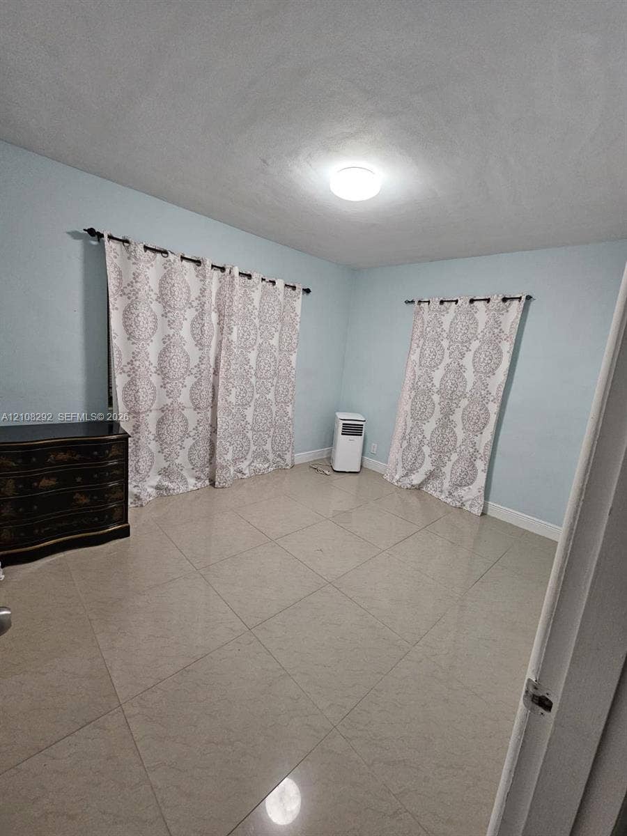3556 N 10th Avenue N, Palm Springs, FL 33461 Light-filled room featuring large-format tile flooring and neutral wall paint