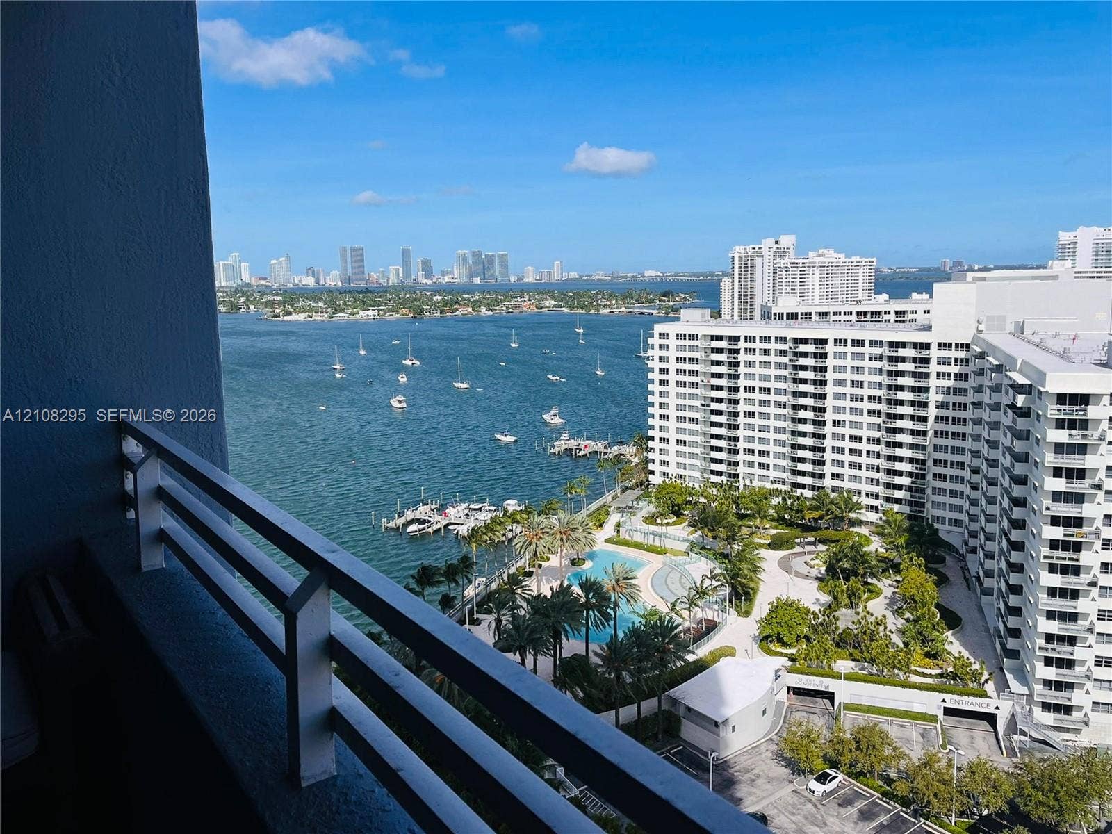 Private balcony featuring a metal railing with a wide-angle perspective of the waterfront, marina, and city skyline