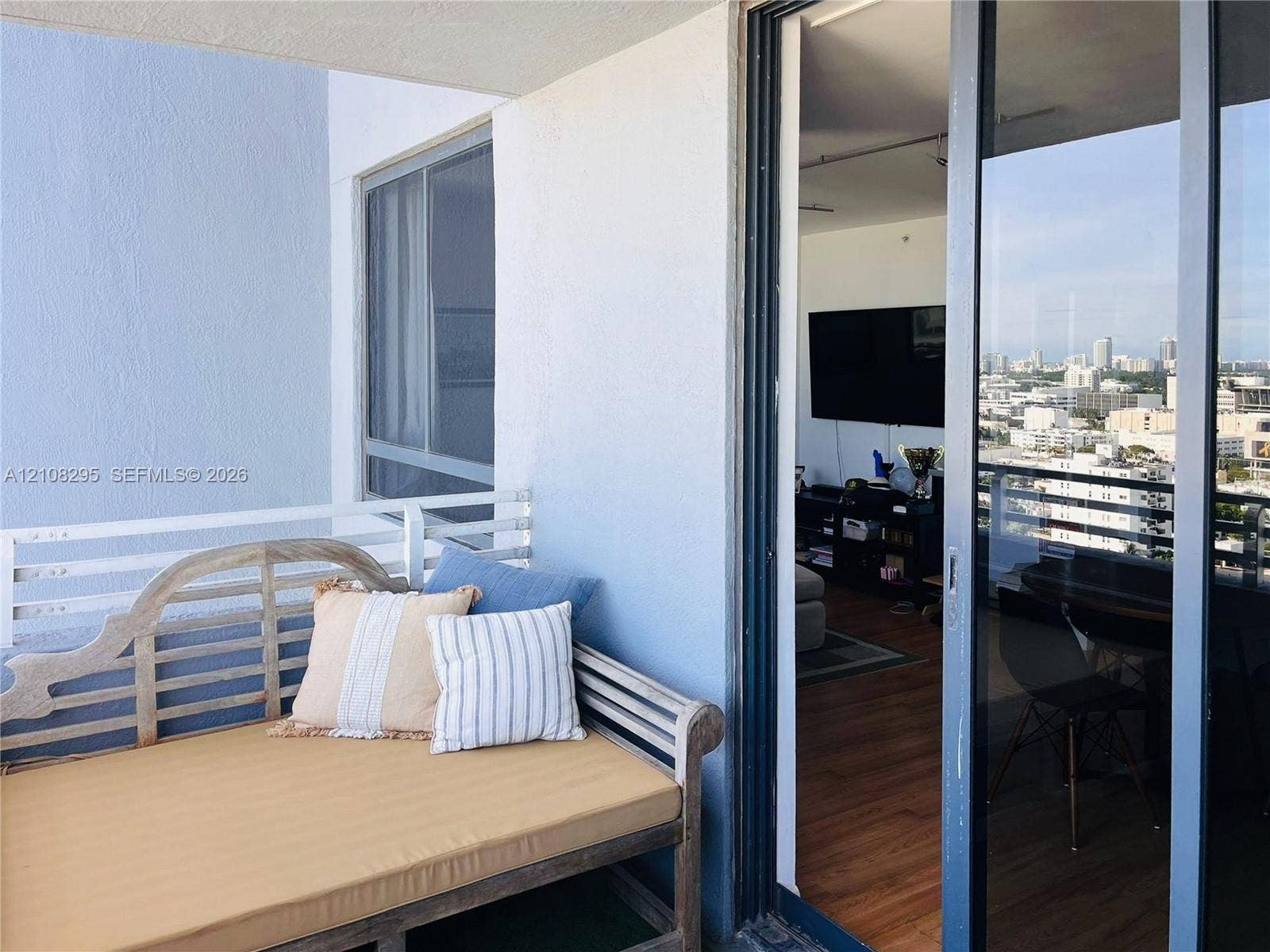 Private balcony featuring a white metal railing and sliding glass door entrance
