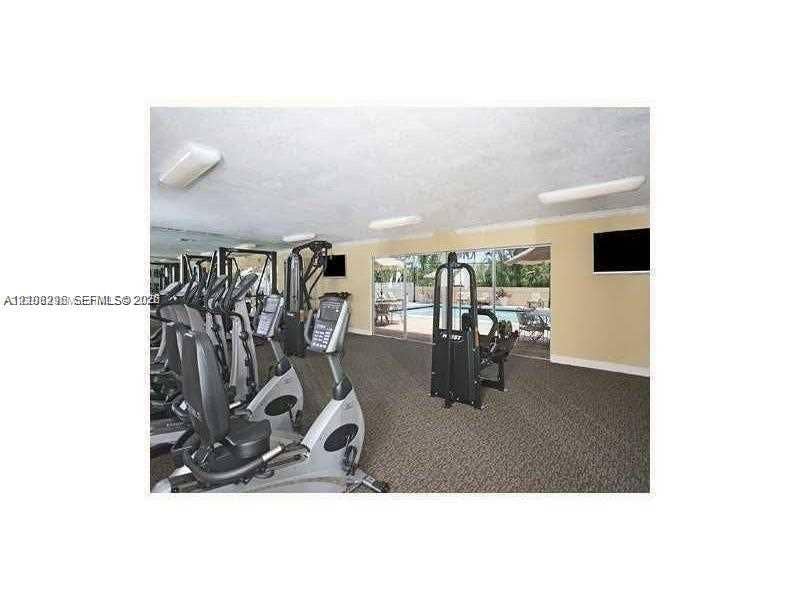 1800 Sans Souci Boulevard, #340, North Miami, North Miami, FL 33181 Fitness center featuring wall-to-wall carpeting, flush-mount lighting, and floor-to-ceiling glass sliding doors