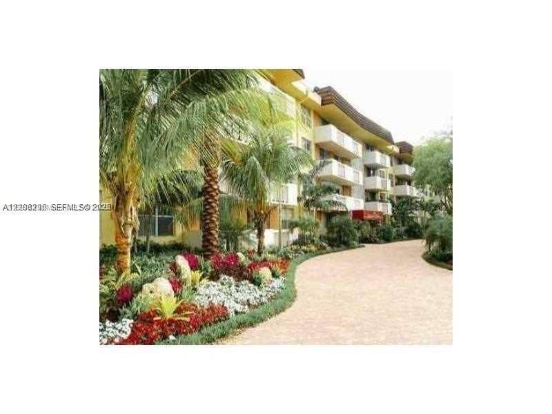 1800 Sans Souci Boulevard, #340, North Miami, North Miami, FL 33181 Multi-story exterior featuring private balconies, paver-style walkway, and landscaped grounds with mature palm trees and flowering foliage