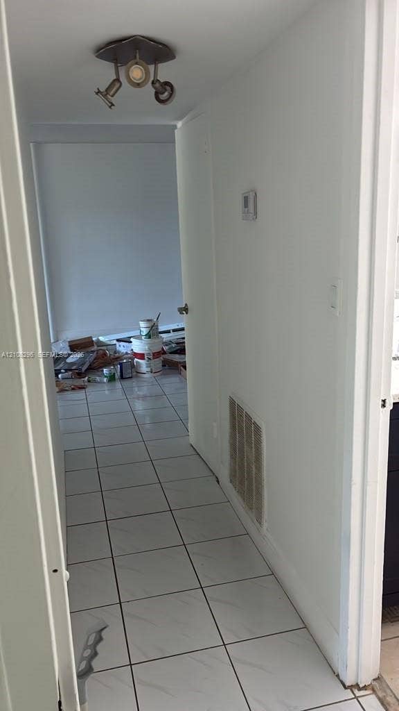 1800 Sans Souci Boulevard, #340, North Miami, North Miami, FL 33181 Hallway featuring light-toned tile flooring and a metallic three-light adjustable track fixture