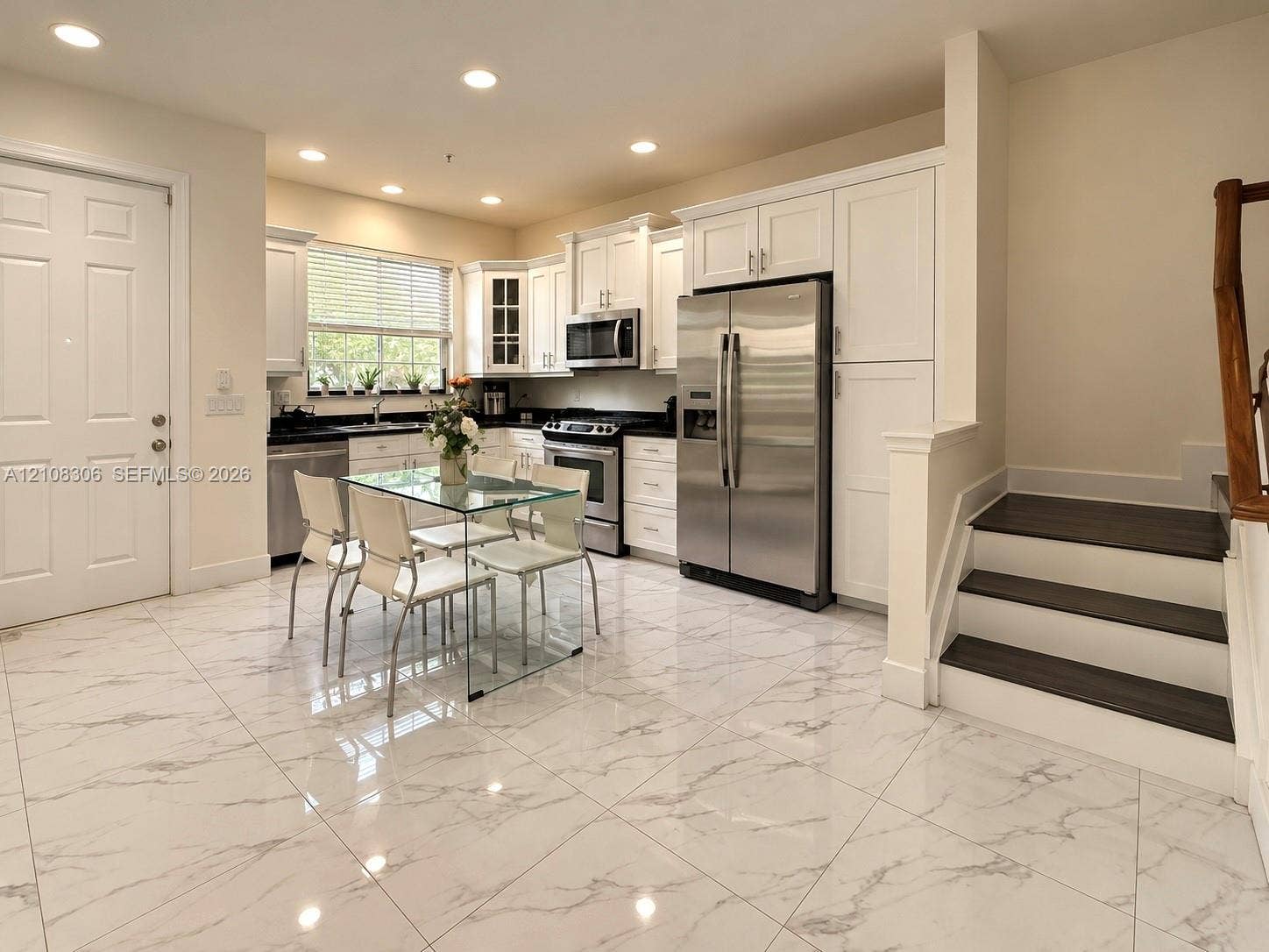 Kitchen featuring large-format tile flooring, white cabinetry, dark stone countertops, stainless steel appliances, and recessed lighting