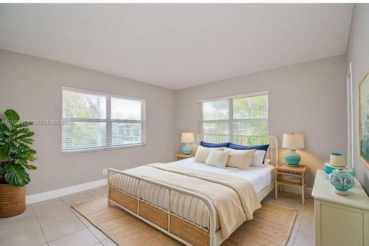 770 SE 2nd Avenue, #E201, Deerfield Beach, FL 33441 Neutral-toned interior space featuring light-colored tile flooring, expansive multi-pane windows, and high-reaching ceilings