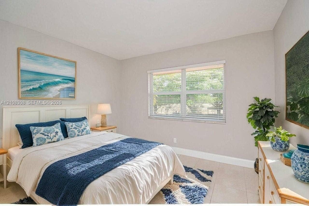 770 SE 2nd Avenue, #E201, Deerfield Beach, FL 33441 Neutral-toned interior walls featuring a large multi-pane window with horizontal blinds and light-colored tile flooring