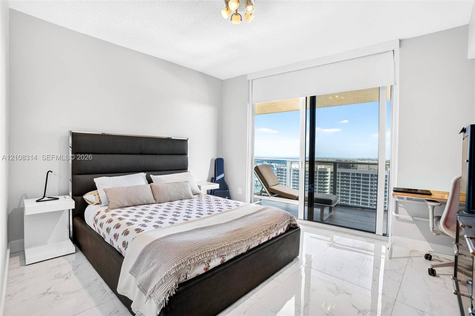 488 NE 18th Street, #4010, Miami, FL 33132 Floor-to-ceiling sliding glass doors, white large-format stone-finish flooring, and recessed ceiling lighting