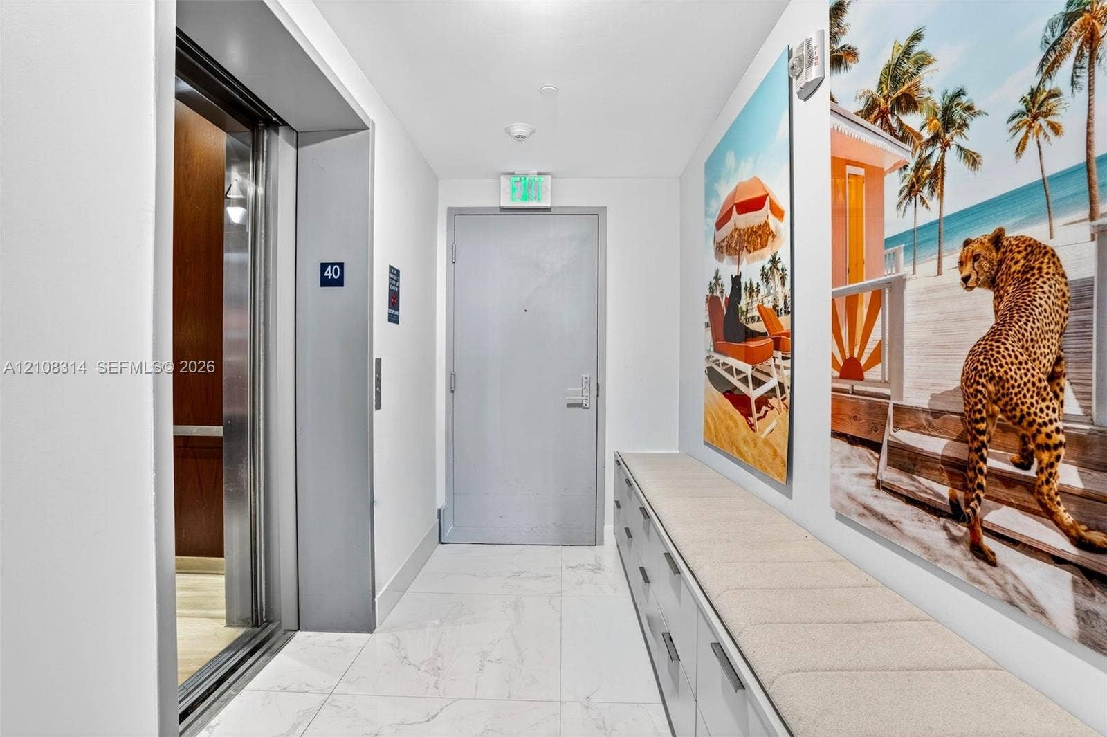 488 NE 18th Street, #4010, Miami, FL 33132 Elevator access featuring metallic sliding doors, white large-format stone-look floor tiles, and custom built-in cabinetry with a stone countertop