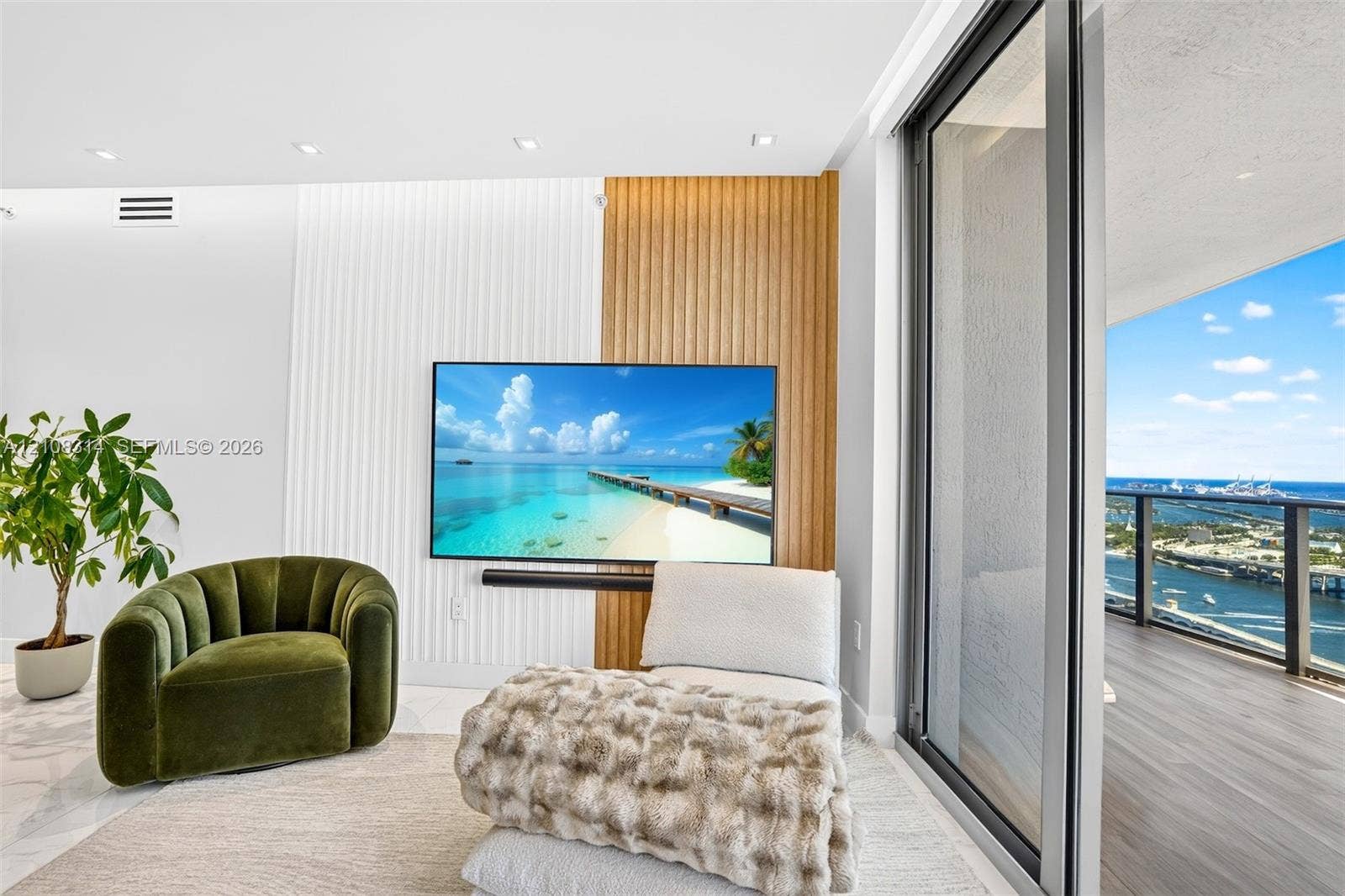 488 NE 18th Street, #4010, Miami, FL 33132 Custom accent wall featuring vertical wood-slat and fluted detailing, recessed ceiling lighting, and expansive floor-to-ceiling sliding glass doors leading to a private balcony