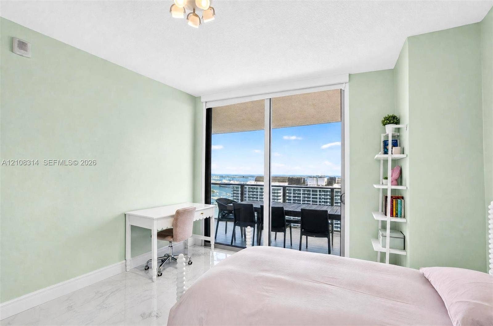 488 NE 18th Street, #4010, Miami, FL 33132 Room with large glass sliding doors, polished stone-finish flooring, and built-in white shelving, providing access to a private balcony